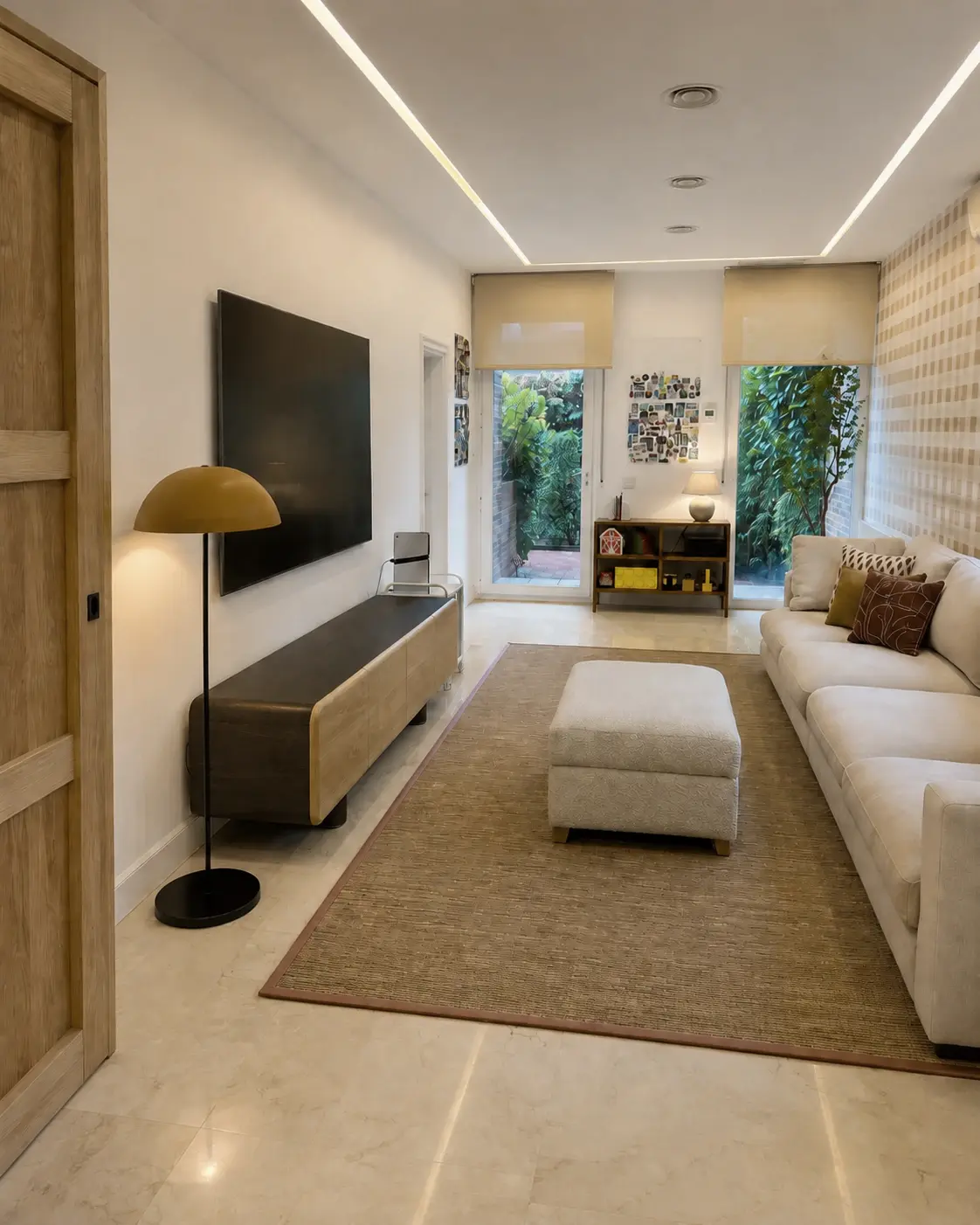Sala de televisión luminosa con sofá blanco y detalles en madera en La Moraleja
