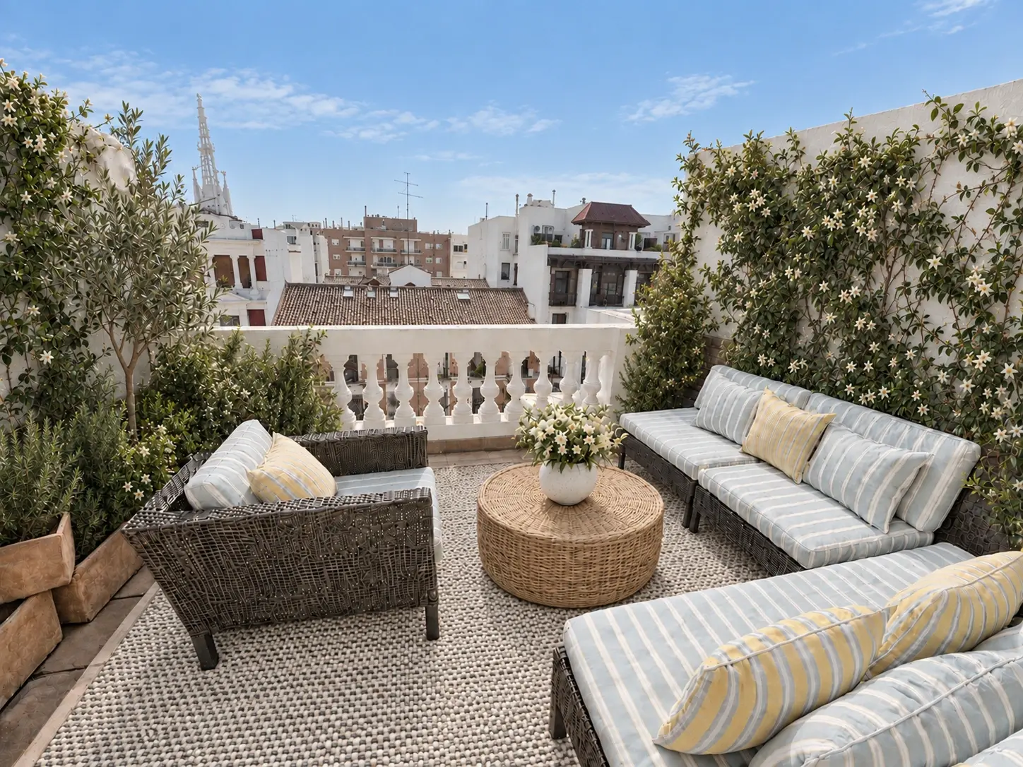 Terraza en el barrio de Salamanca con vistas urbanas reales, vegetación mediterránea y alfombra tejida en crudo y negro